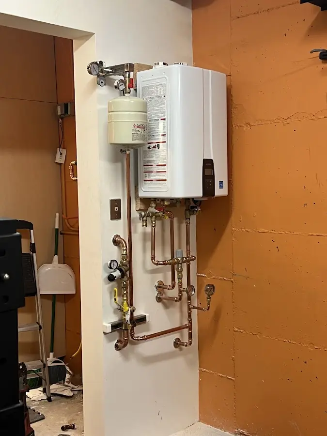 Plumbing technician inspecting water heater connections in Escalon